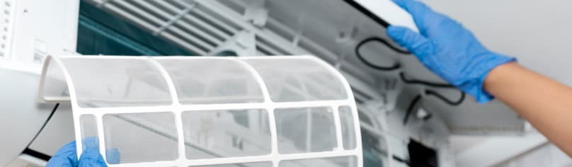 Image of a professional cleaning an air conditioner
