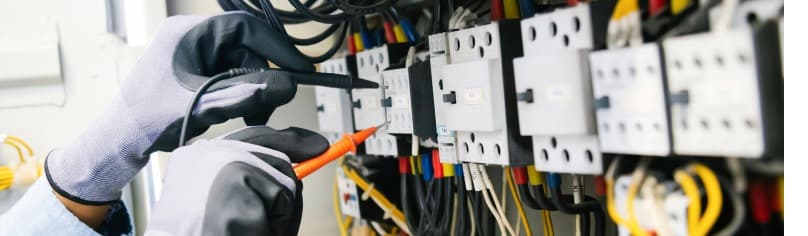 Image of an electrician performing electrical work